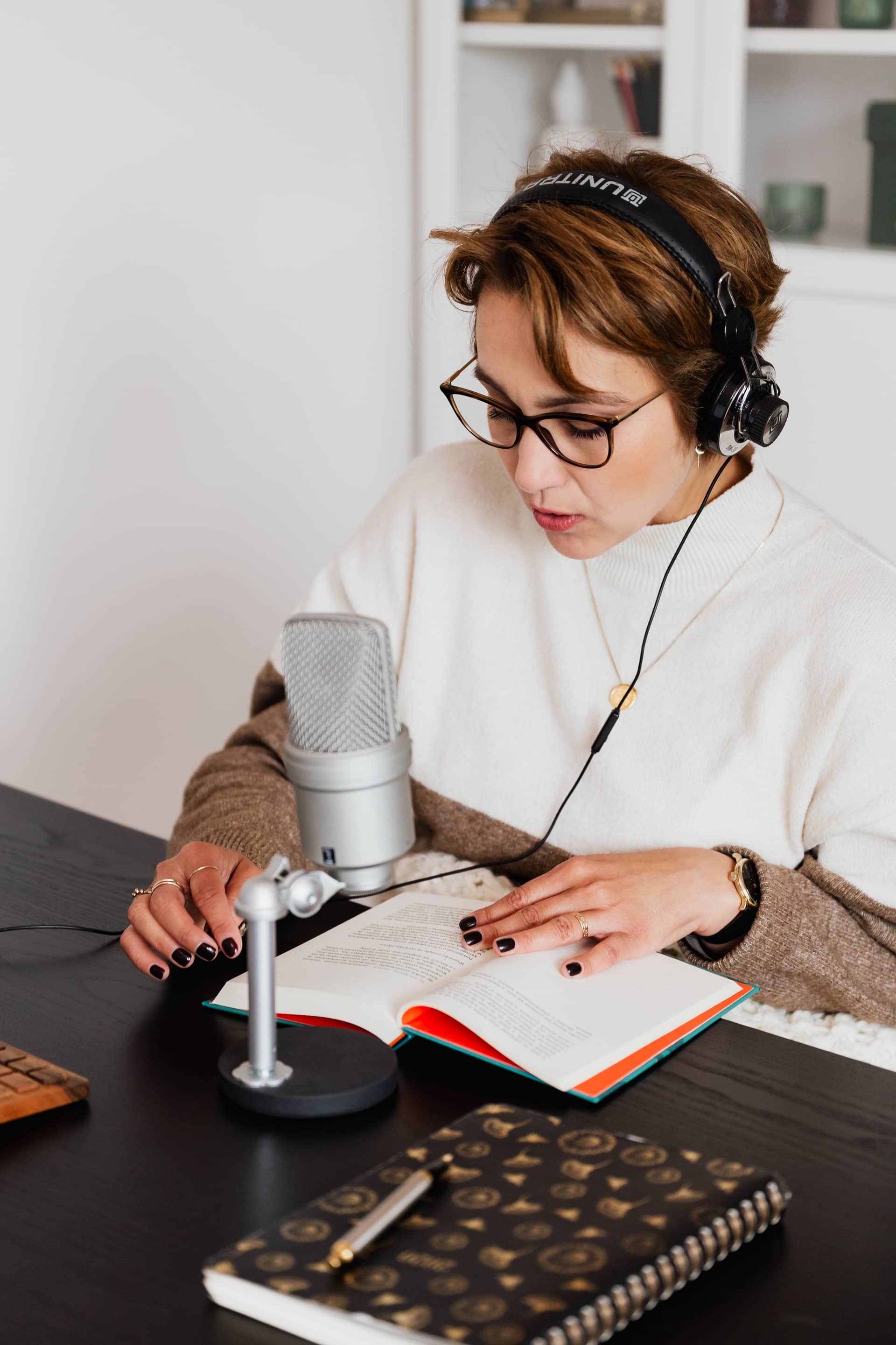 Narrator recording an audiobook at a studio microphone