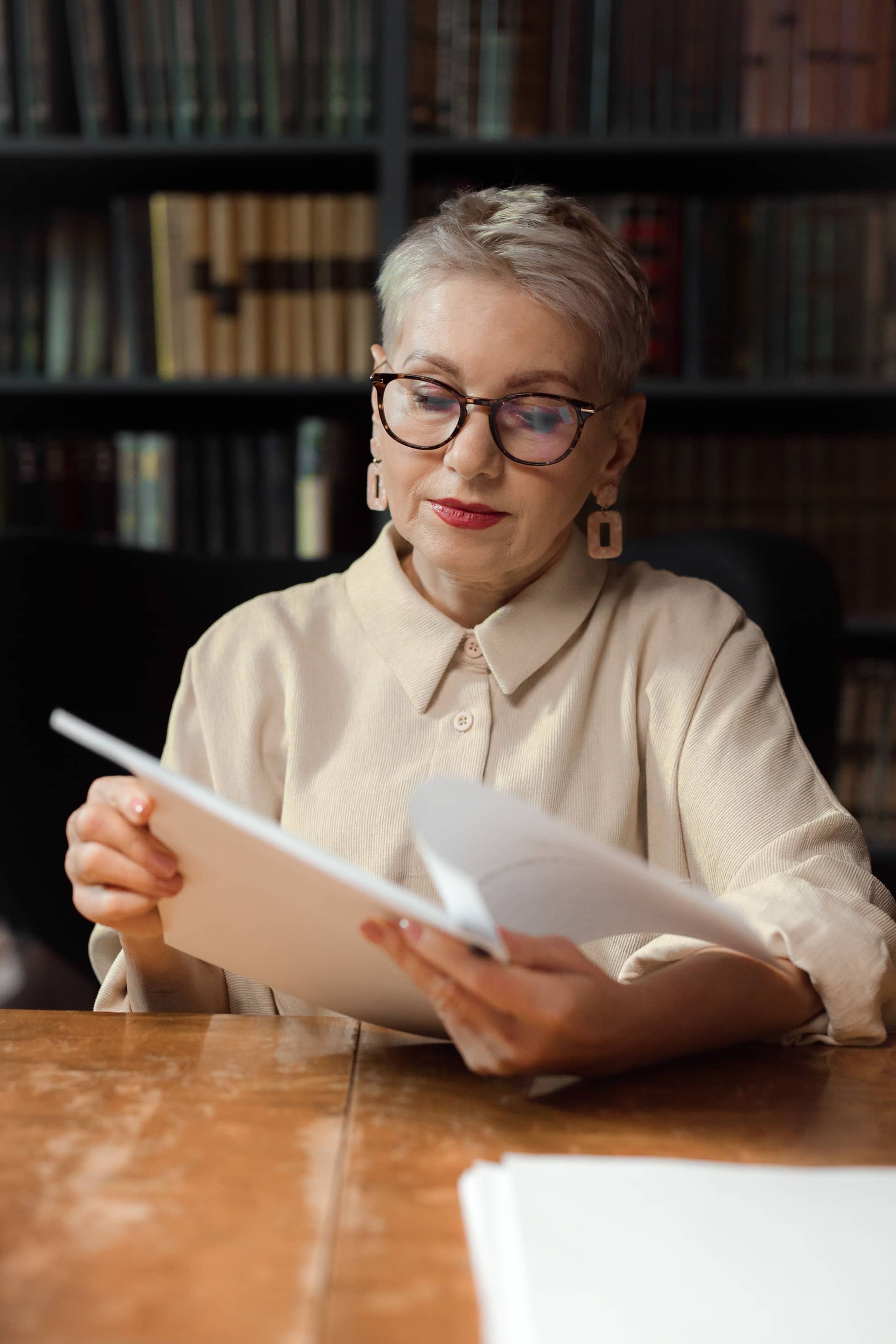 Author reviewing a printed manuscript at her desk